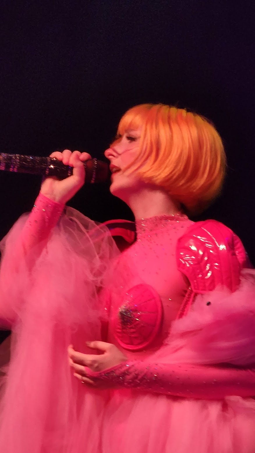 Close-up of Tessa Violet singing, facing to the side