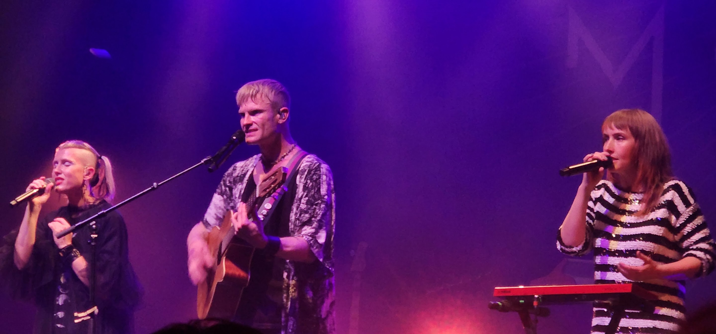 Three members of Mother Mother performing