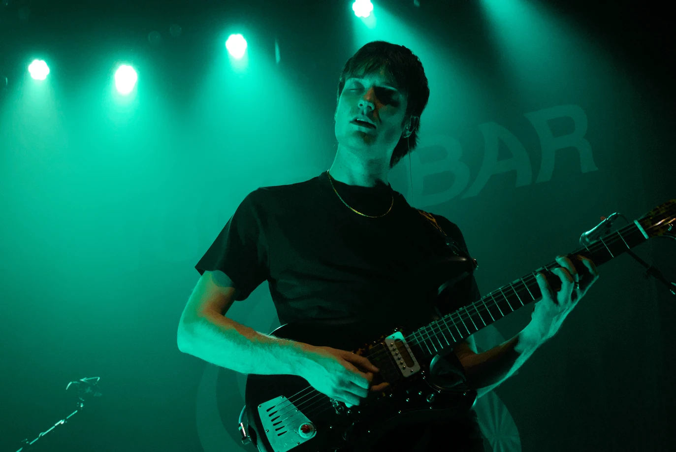 Vundabar's Brandon playing guitar in teal light