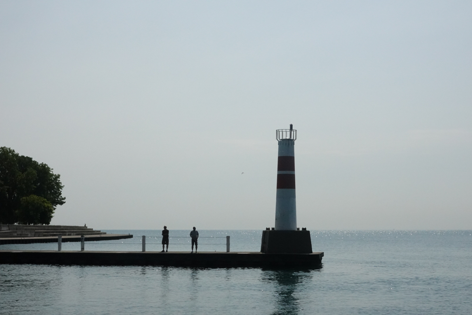 Two people standing in front of a lighthouse at Montrose Moonrise Vista Point