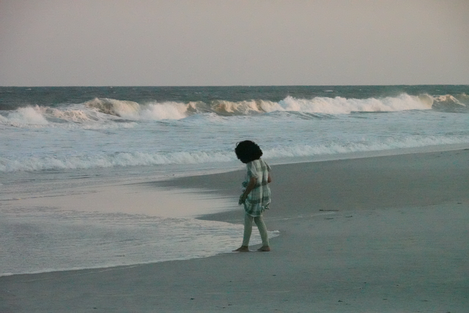 Shot of girl approaching the water at the beach